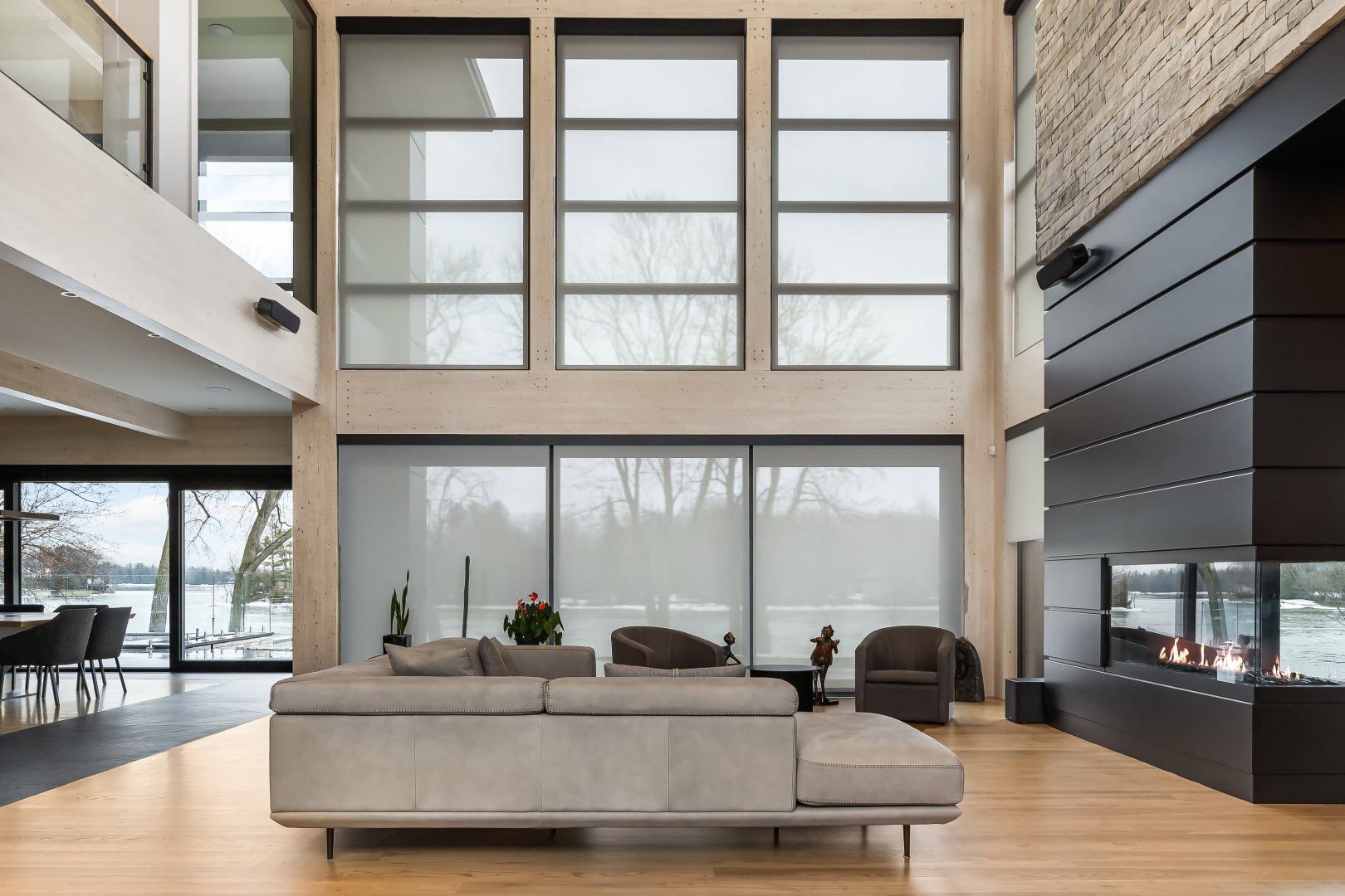 A living room with Clara motorized roller shades lowered across a wide window.